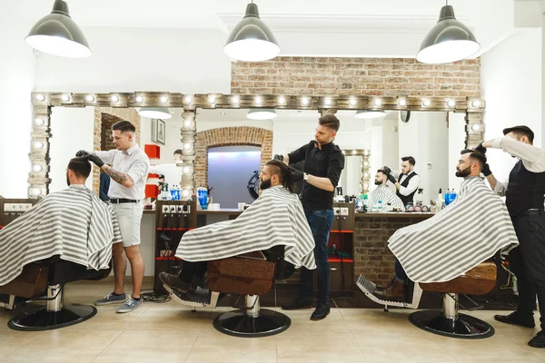 Barbeiros fazendo cortes de cabelo para clientes — Fotografia de Stock
