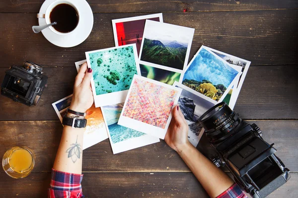 Las manos de la mujer sosteniendo fotos impresas — Foto de Stock