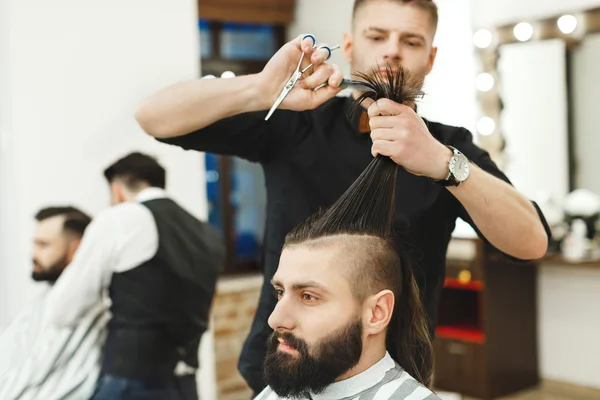 Dark haired barber doing a haircut — Stock Photo, Image