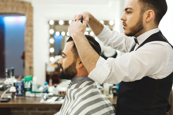 Barbiere dai capelli scuri che fa un taglio di capelli — Foto Stock