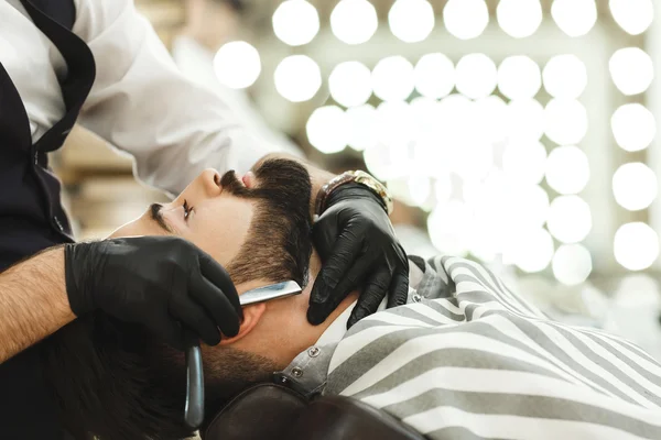 Mãos em luvas fazendo forma de barba — Fotografia de Stock