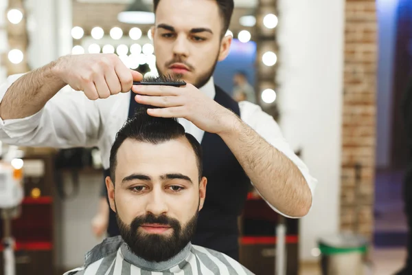 Barbiere dai capelli scuri che fa un taglio di capelli — Foto Stock