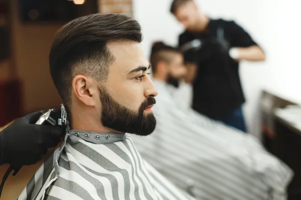 Man with dark hair doing a haircut — Stock Photo, Image