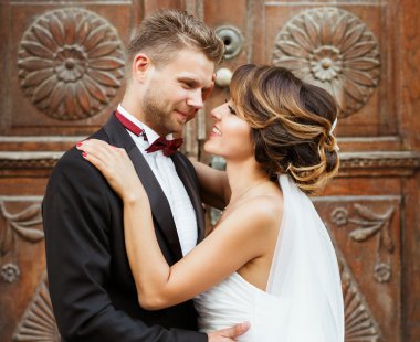 Damat ve gelin ahşap kapının yanında kucaklayan 