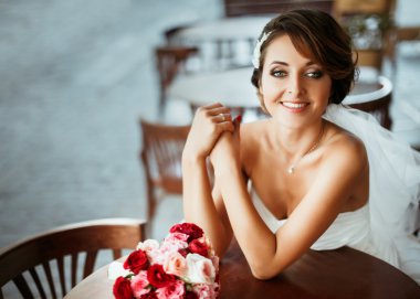 Gelin buketi ile kafede oturan