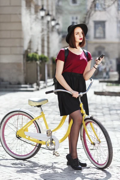 Красивая девушка на велосипеде с телефоном — стоковое фото