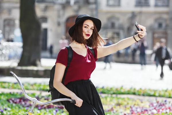 Vacker flicka på cykel att göra selfie — Stockfoto