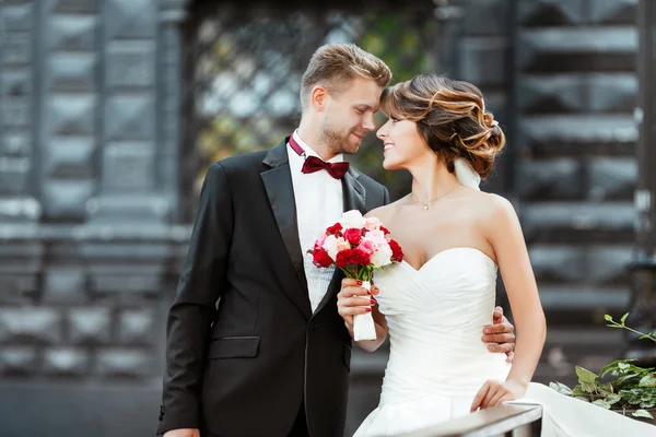 Sposa e sposo in piedi con bouquet — Foto Stock
