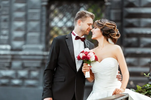 Bruid en bruidegom staan met boeket — Stockfoto