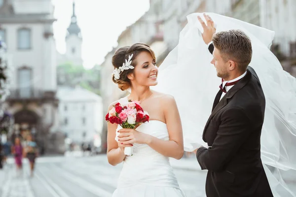 Bruidegom bedrijf sluier voor de bruid — Stockfoto
