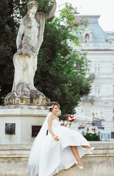 Braut sitzt in der Nähe von Denkmal — Stockfoto