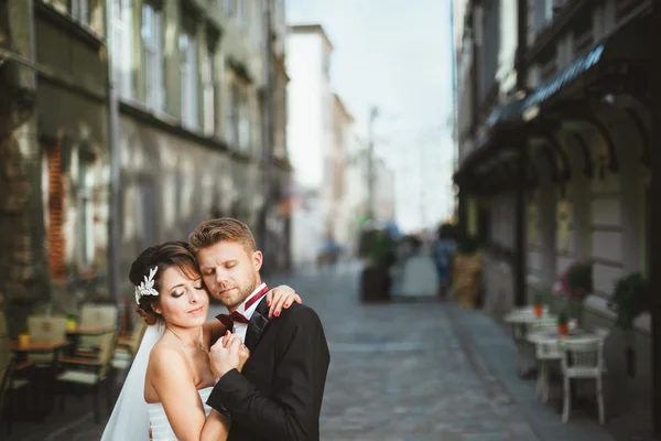 Bruid en bruidegom omarmen op straat — Stockfoto