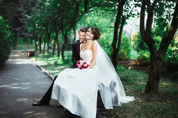 Noiva e noivo sentados no banco — Fotografia de Stock
