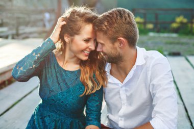 Ahşap yolda gülümseyen oturan çift