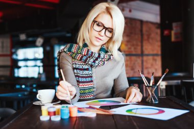 Kafede oturan ve çizim kız