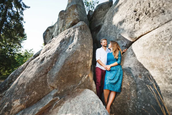 Leende par stående nära klippor — Stockfoto