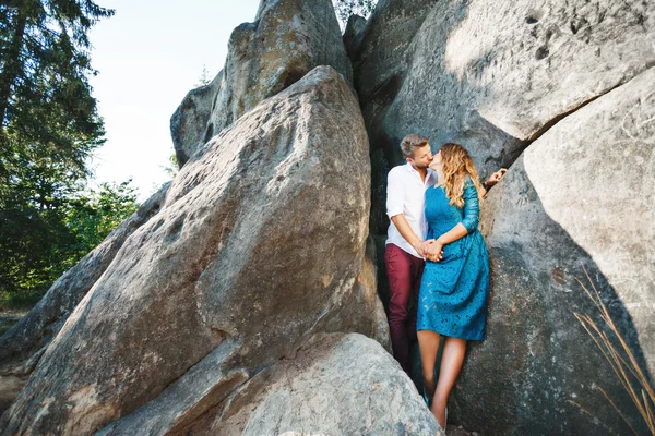 Kissing couple standing near rocks — Stock Photo, Image