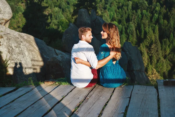 Casal amoroso sentado no caminho de madeira e abraçando — Fotografia de Stock