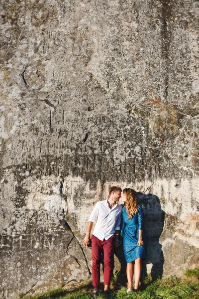 Bonito casal de pé perto da parede de pedra — Fotografia de Stock