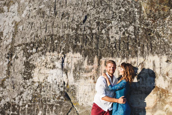 Nice couple standing near stone wall — Stock Photo, Image