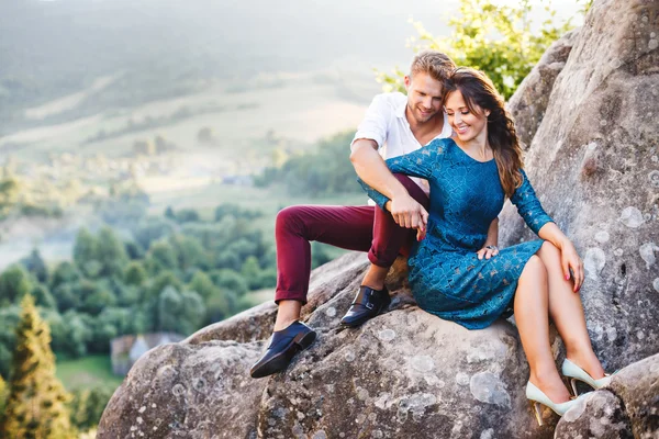 Casal sorridente na rocha alta — Fotografia de Stock