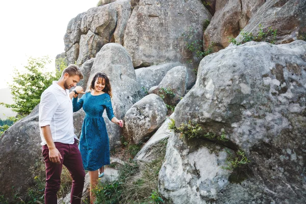 Homme menant sa petite amie parmi les rochers — Photo