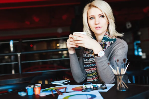 Blondynka, siedząc w kawiarni, z filiżanką herbaty — Zdjęcie stockowe