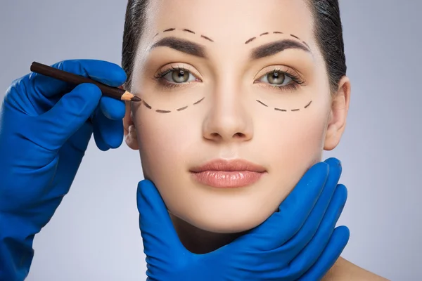 Cirujano plástico dibujando líneas discontinuas debajo del ojo — Foto de Stock