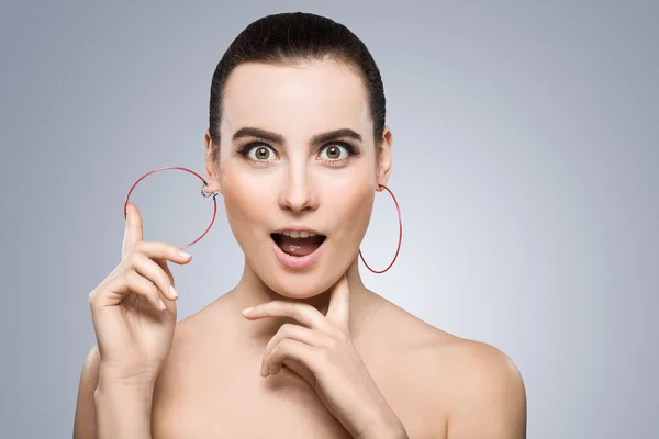 Surprised girl touching big round earring — Stock Photo, Image