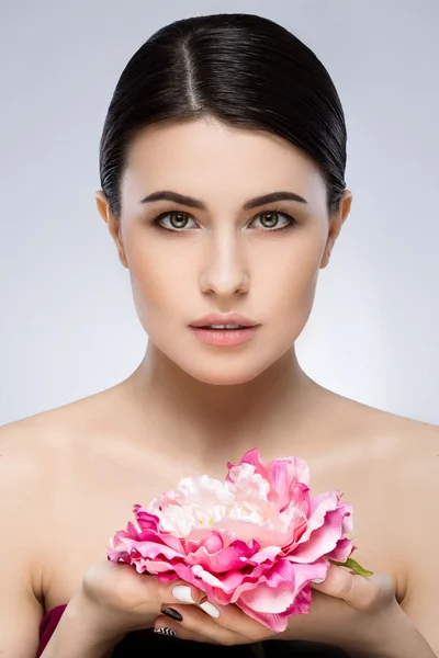 Menina bonita com ombros nus segurando flor — Fotografia de Stock