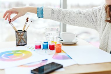 Woman's hand touching paint brush
