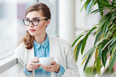 Şirin kız fincan kahve ile ayakta