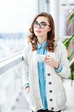 Şirin kız fincan kahve ile ayakta