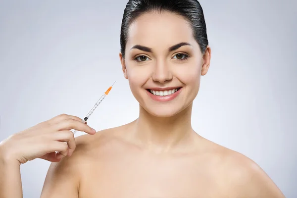 Chica encantadora con maquillaje desnudo en el estudio y sonriendo — Foto de Stock