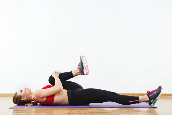 Attractive fit girl doing physical exercises at gym — Stock Photo, Image