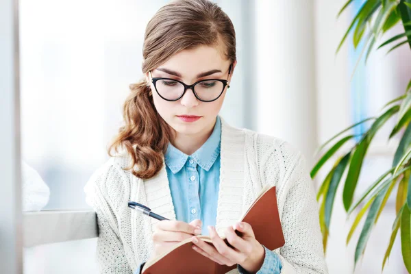 Preciosa chica con gafas de pie con portátil — Foto de Stock