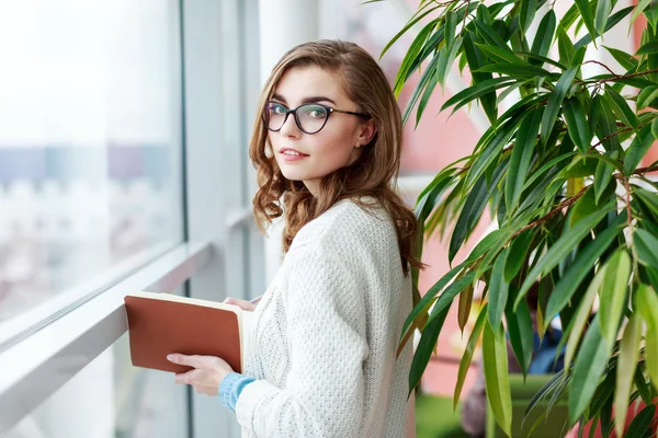 Preciosa chica con gafas de pie con portátil —  Fotos de Stock