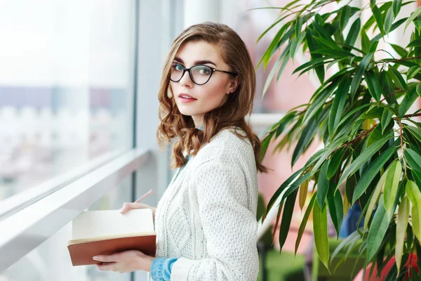 Preciosa chica con gafas de pie con portátil —  Fotos de Stock