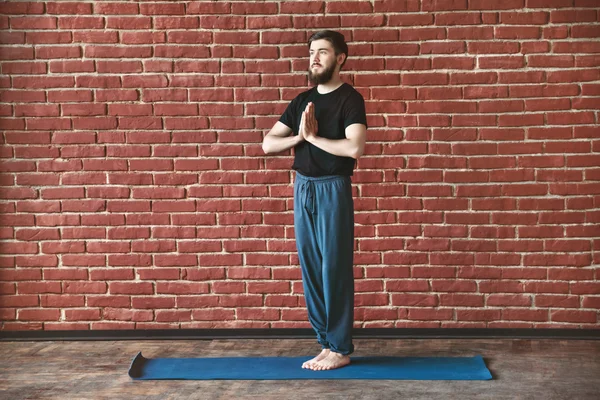 Hombre guapo haciendo posiciones de yoga — Foto de Stock