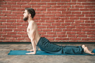 Yakışıklı adam yoga pozisyonları yapıyor