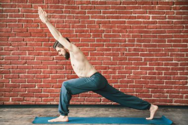 Yakışıklı adam yoga pozisyonları yapıyor