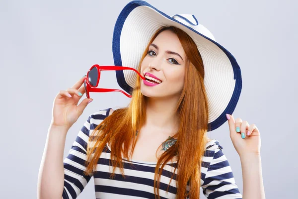 Tyttö hattu, raidallinen T-paita ja aurinkolasit — kuvapankkivalokuva