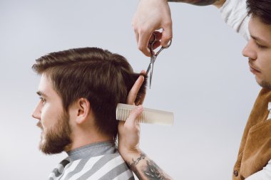 Attractive barber doing a haircut clipart