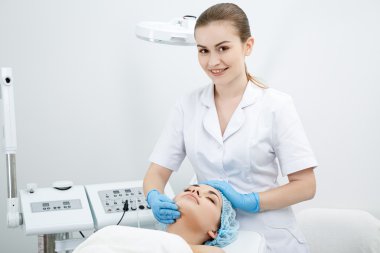 Doctor massaging girl's face clipart