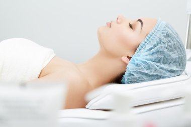 Kozmetoloji kliniğinde kanepede yatan model