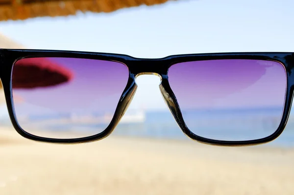 Černé sluneční brýle na pozadí moře — Stock fotografie