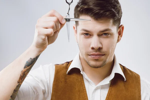 Peluquero guapo en fondo gris — Foto de Stock