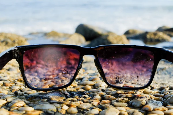 Чорні сонцезахисні окуляри на морському фоні — стокове фото