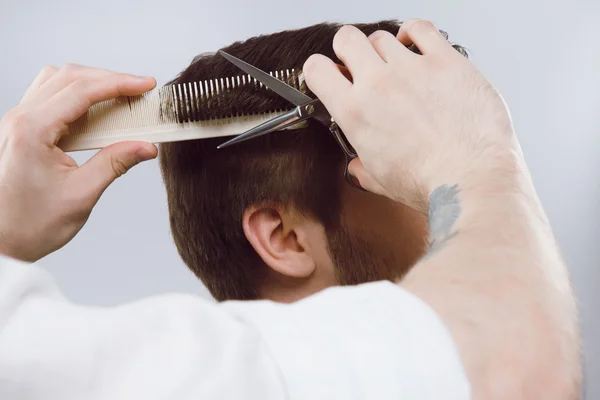Les mains du coiffeur font une coupe de cheveux — Photo
