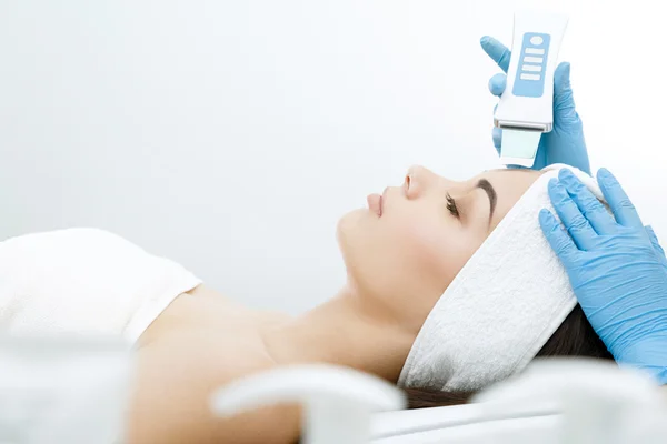 Médico fazendo procedimento de limpeza ultrassônica de cara — Fotografia de Stock